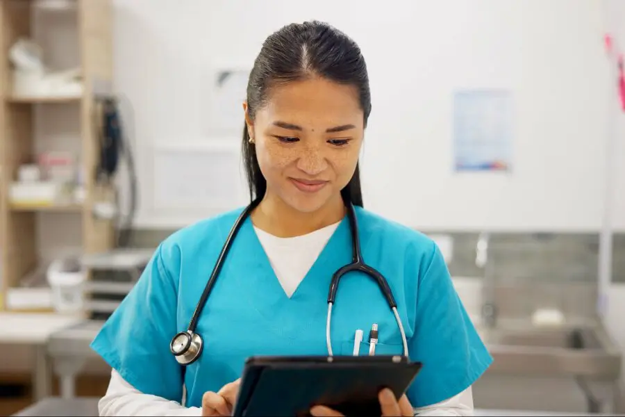 Young veterinarian with tablet for animal health, study or browsing at clinic. Female person or veterinarian scrolling on technology for medical search or pet treatment